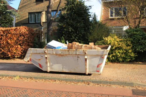 Waste being loaded into a skip by professionals